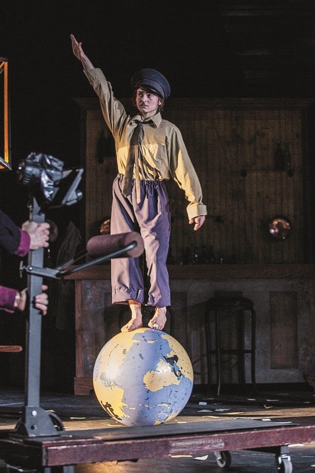 Milena Dabova plays Hitler, balancing on top of a globe, in "The Grand Parade," a touring production by Double Edge Theatre of Massachusetts. (Photo by Maria Baranova)