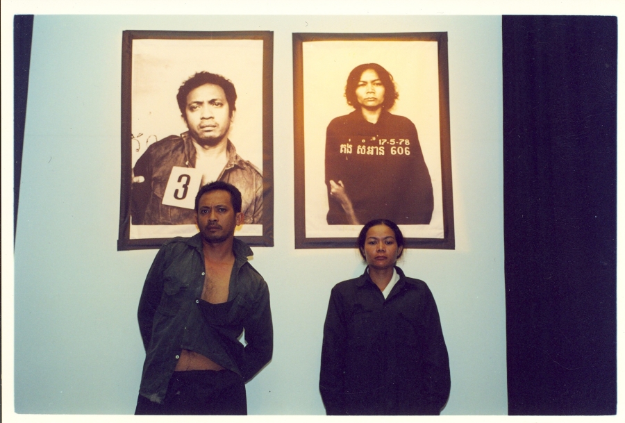 Actors Roeun Narith and Morm Sokly with photos of torture victims, in Catherine Filloux's 'Photographs from S-21,' directed by Thenn Nan Doeum in Phnom Penh in 2001. (Photo by Mark Remissa)